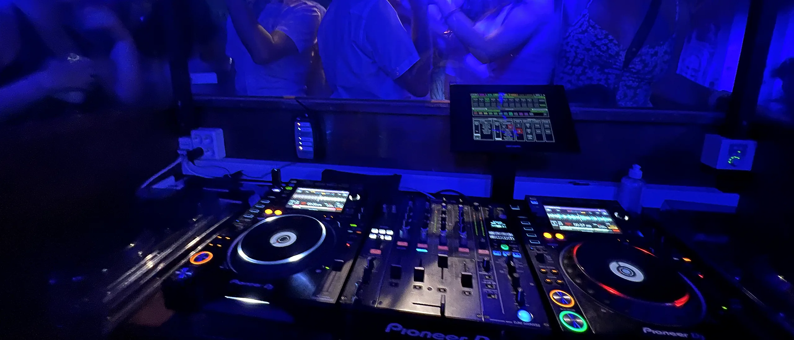Udsigten fra DJ-pulten ud over dansegulvet i blåt lys